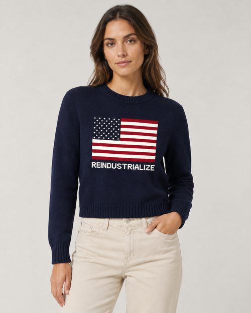 Woman wearing a navy sweater with an American flag design and text on a plain background