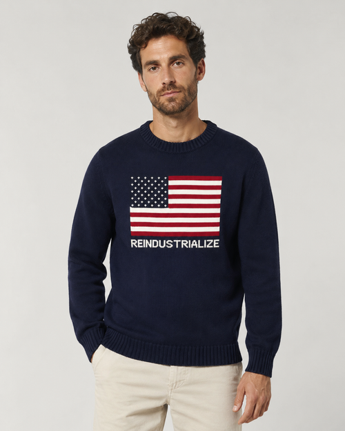 Man wearing a navy sweater with an American flag and text on a light gray background